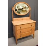 An antique ash dressing chest with three drawers and oval mirrored back.80 by 90 by 43cm.