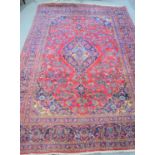 An Iranian wool rug with purple and blue borders bearing palmette motifs198cm by 294cm