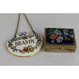 A vintage enamelled pill box, together with a ceramic Brandy bottle tag.