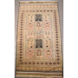 A cream ground Middle Eastern wool rug with geometric stylised borders180cm by 94cm