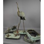 A pair of cast metal garden cranes, green patination, both A/F