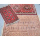 A Tekke beige ground wool rug together with two middle eastern rugs with red ground93cm by 144cm -