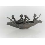 An African bronze model of four figures in a boat24.5cm by 8.5cm high