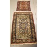 Two Middle eastern rugs the smaller having a red ground and the other cream with orange borders