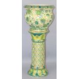 A 20th century Chinese ceramic jardiniere and stand decorated in green 62cm high.