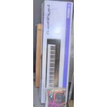 A Yamaha Piaggero digital keyboard with stand, both boxed, together with various sheet music and
