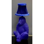 A modern table lamp in the form of a blue monkey