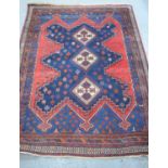 An Iranian Sirjan wool rug with red and blue ground198cm by 149cm