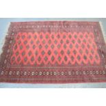 A Tekke rug with a pink ground and Kufic style border125cm by 190cm