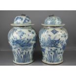 A pair of antique Chinese blue and white vases, with metal hoop handle to the covers, decorated with