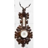 A 19th century Blackforest barometer, carved with a stag, and the dial bordered by foliate