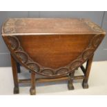 An oak gateleg table, with two drop leaves carved with decoration, 76 by 150 by 55cm leaves down.