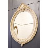 A reproduction white painted oval wall mirror in the 19th century style152cm high by 104cm wide