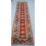 A large wool runner with geometric stylised borders310cm by 84cm