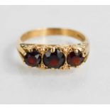 An antique 9ct gold and garnet ring, the three brilliant cut graduated garnets in claw setting, size