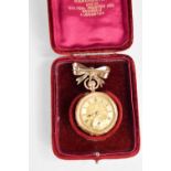 A 14ct gold ladies pocket watch, with engraved chased decoration, and hung on a bow form brooch, the