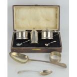 A boxed silver cruet set, comprising salt and mustard pots, each with blue glass liner and spoons,