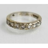 An 18ct white gold and diamond set half hoop eternity ring, size N, the seven diamonds totaling 0.