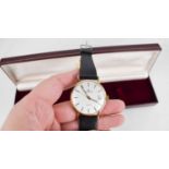 A 9ct gold Garrard wristwatch with leather strap, inscription to the case, with box.