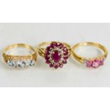 A 9ct gold, pink sapphire and diamond cluster ring, a 9ct gold and pink topaz three stone ring, both