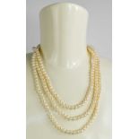 A 9ct gold and pearl triple strung necklace, the gold clasp in the form of chinese calligraphy,