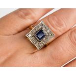 An 18ct gold, platinum, diamond and sapphire ring, of square form, the cushion cut sapphire bordered