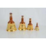 A group of four Bells whisky decanters, full, two sealed.