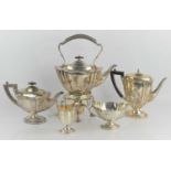 A silver tea set with kettle and stand, of Art Nouveau curvilinear design, with ebony handles and