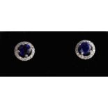 A 9ct white gold sapphire and diamond cluster halo earrings.