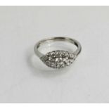 A white metal, and diamond set cluster ring, set in boat form, all round brilliant cut in a claw