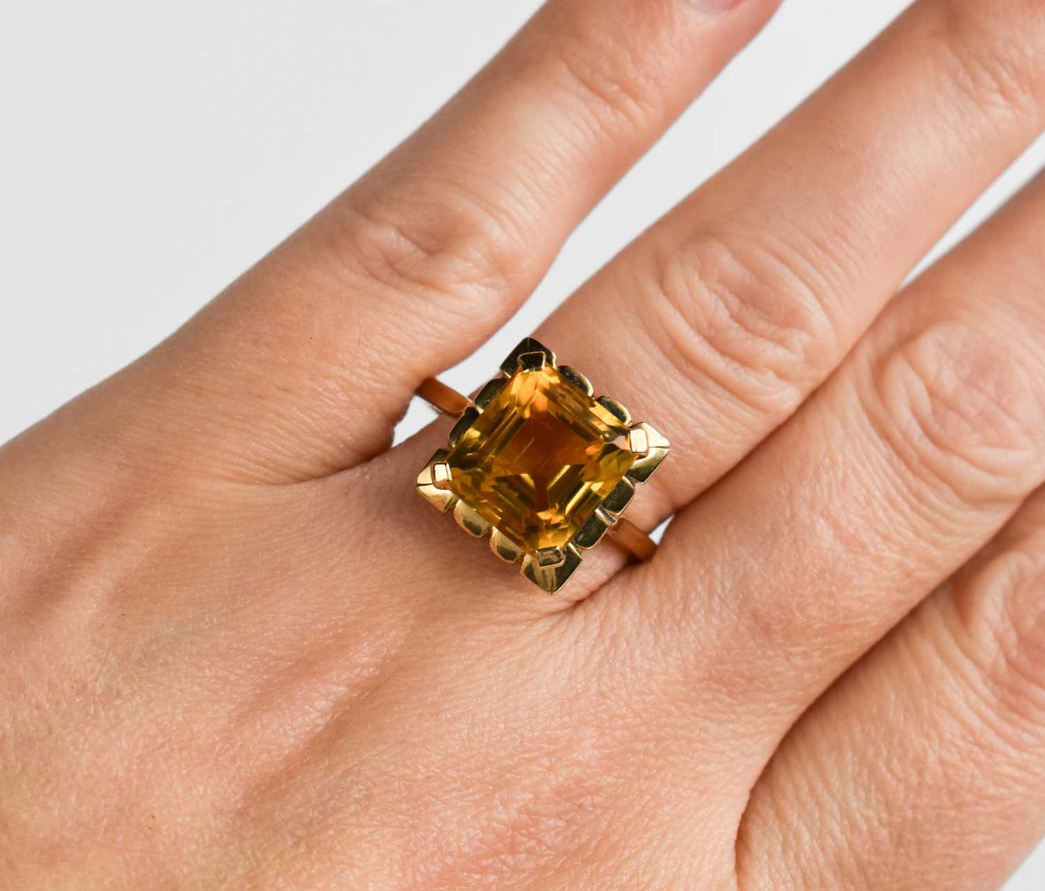 A 9ct gold and emerald cut citrine dress ring, size R, stone of strong slightly bronze colour 9.1 by