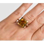 A 9ct gold and emerald cut citrine dress ring, size R, stone of strong slightly bronze colour 9.1 by