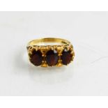 A 9ct gold and garnet three stone ring, size M, 3.5g.