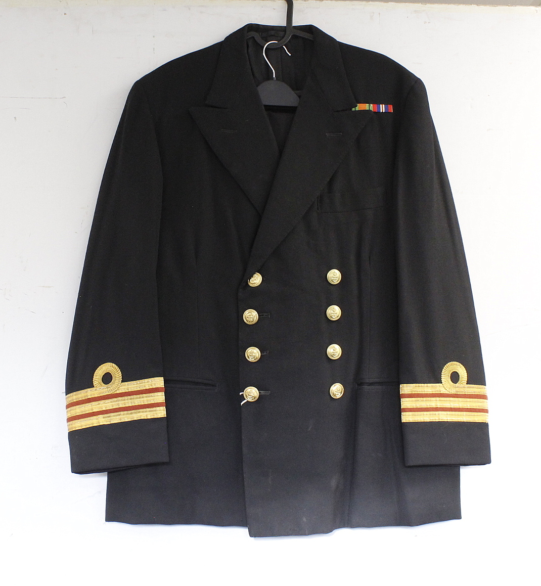 British Royal Navy dress uniform jacket having brass naval buttons by Gieves Ltd, bullion wire