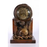 An unusual carved mahogany death clock, the brass dial with gravestone supported by eagle, skull and