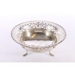 An antique silver fruit basket of circular bowl form with pierced scroll and fleur de lis rim raised