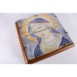 19th century style glazed earthenware tile of female saint, possibly Madonna, within frame, 40cm