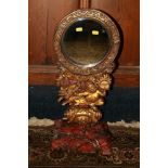 Antique Chinese gilded and lacquered wood mirror of circular form raised on a carving of a figure