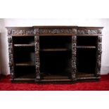 Antique heavily carved oak break front bookcase, frieze fitted with three drawers above carved