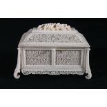 19th century pierced and carved ivory casket of sarcophagus form, on four scroll supports, the
