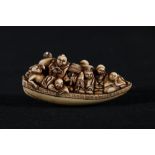 Hand carved netsuke of voyagers in a boat, with two oarsmen, the underside with wave decorations,
