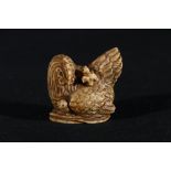 Stained ivory netsuke of a mother hen observing her two chicks, 4cm, signed, 35g, Meiji