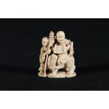 Carved ivory okimono depicting a man holding a scroll and seated on a lion dog, a man beside him