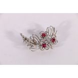 Unhallmarked white metal openwork floral spray brooch set with three pink rubies and twenty-three