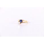 18ct gold diamond and sapphire crossover ring, the diamond approximately 0.3cts, size K, 2.6g