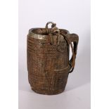Nepalese carved wooden pail with metal band to the rim, base and handles, twisted carrying rope, the
