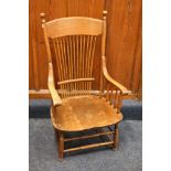 Antique oak comb back armchair with saddled seat raised on turned supports