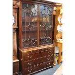 Edwardian mahogany astragal glazed two door bookcase above three drawer chest raised on bracket supp