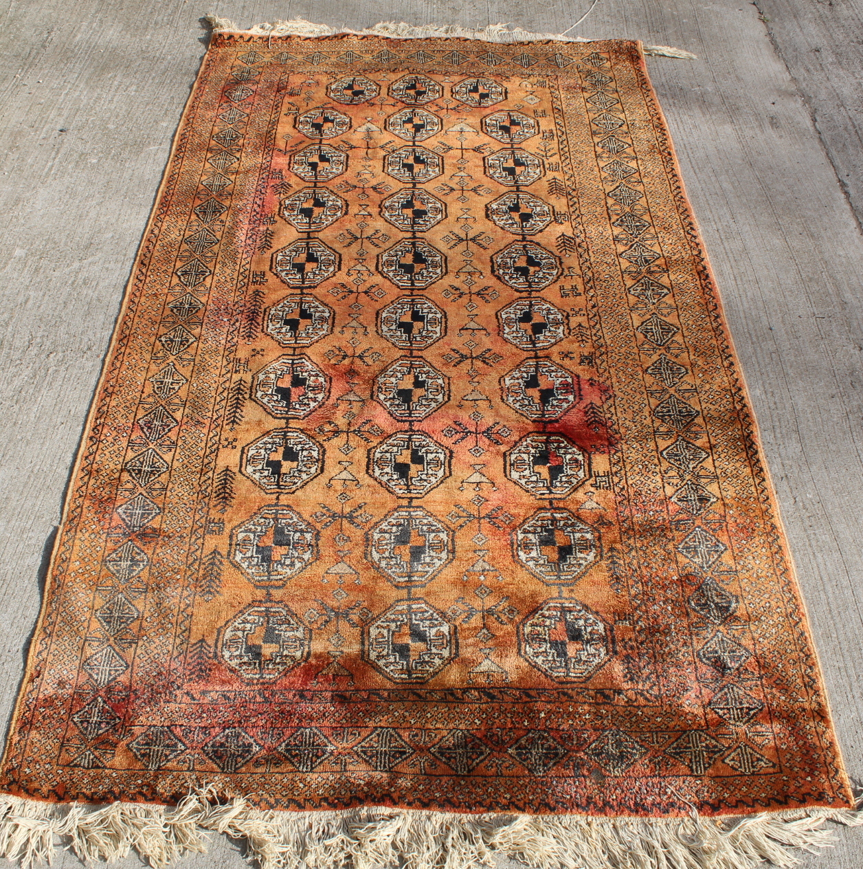 Persian silk on cotton rug, the teracotta field with three rows of octagonal guls, 208cm x 116cm.