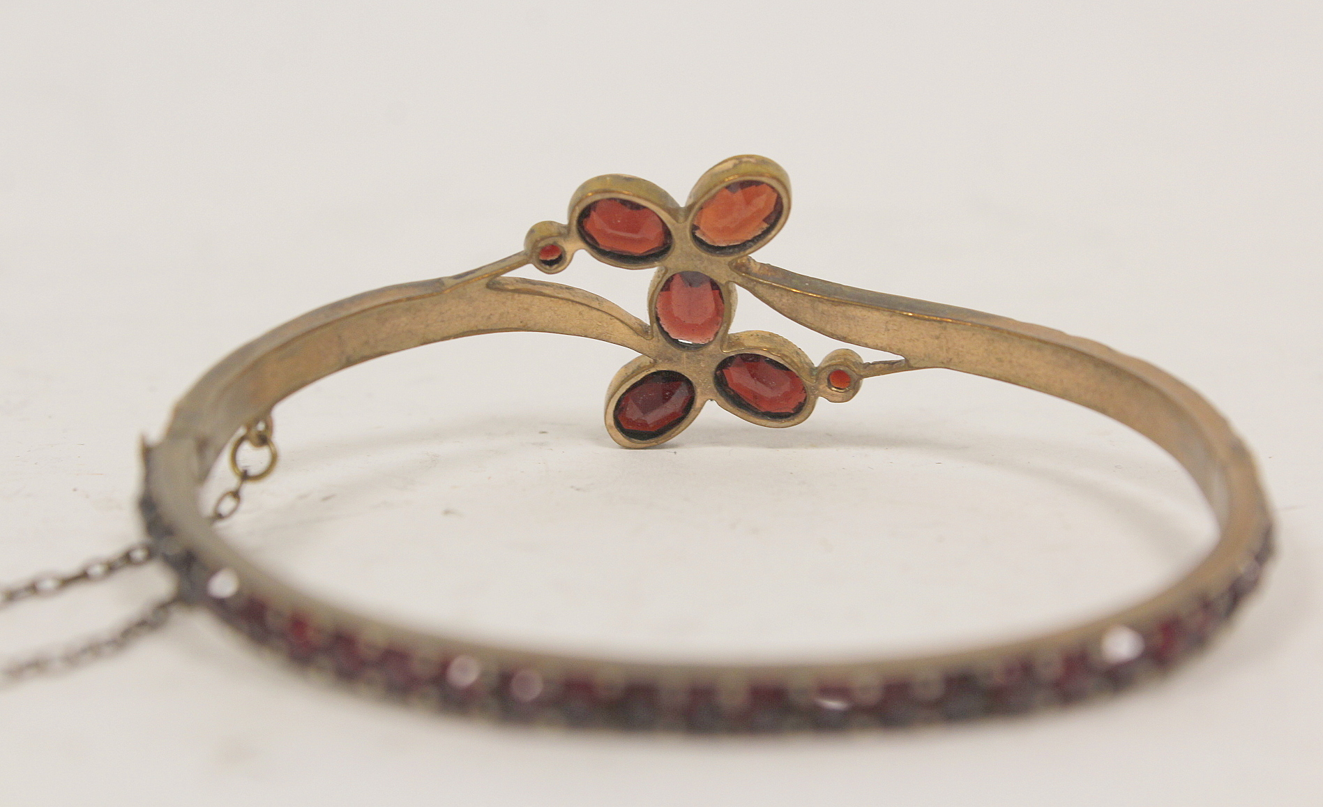 Victorian pyrope garnet hinged bangle in 'garnet' gold and a similar cluster brooch. (2). - Image 3 of 4